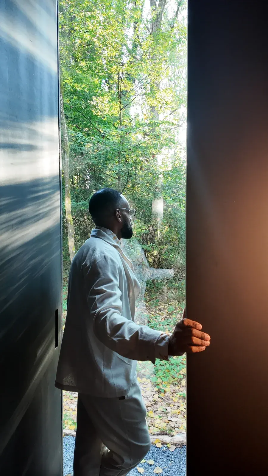 Le dirigeant ouvrant la porte vitrée de la maison miroir